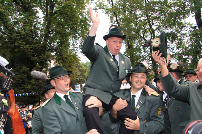 Der neuer König wird auf die Schultern gehoben.